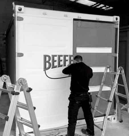 trabajador pintando contenedor de beefeter